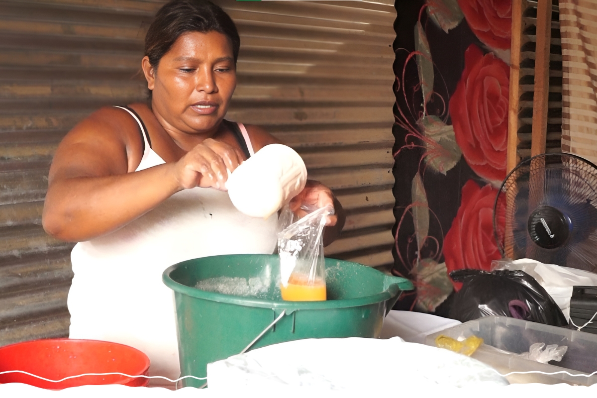 A woman pours juice into a plastic bag.