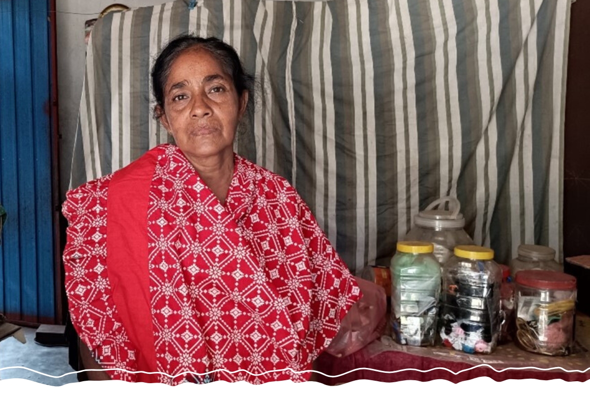 A woman stands next to a counter of sewing goods