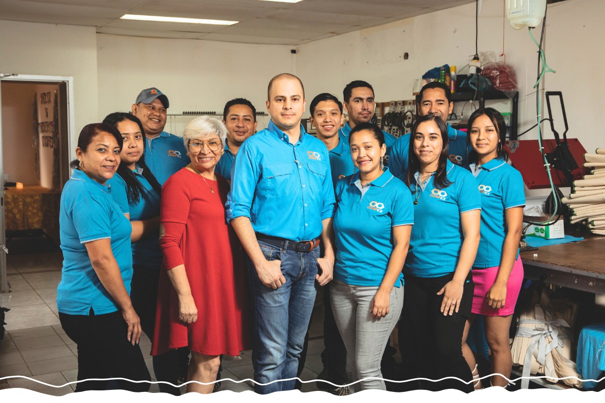 Alejandro stands with the women and men who work in his business.