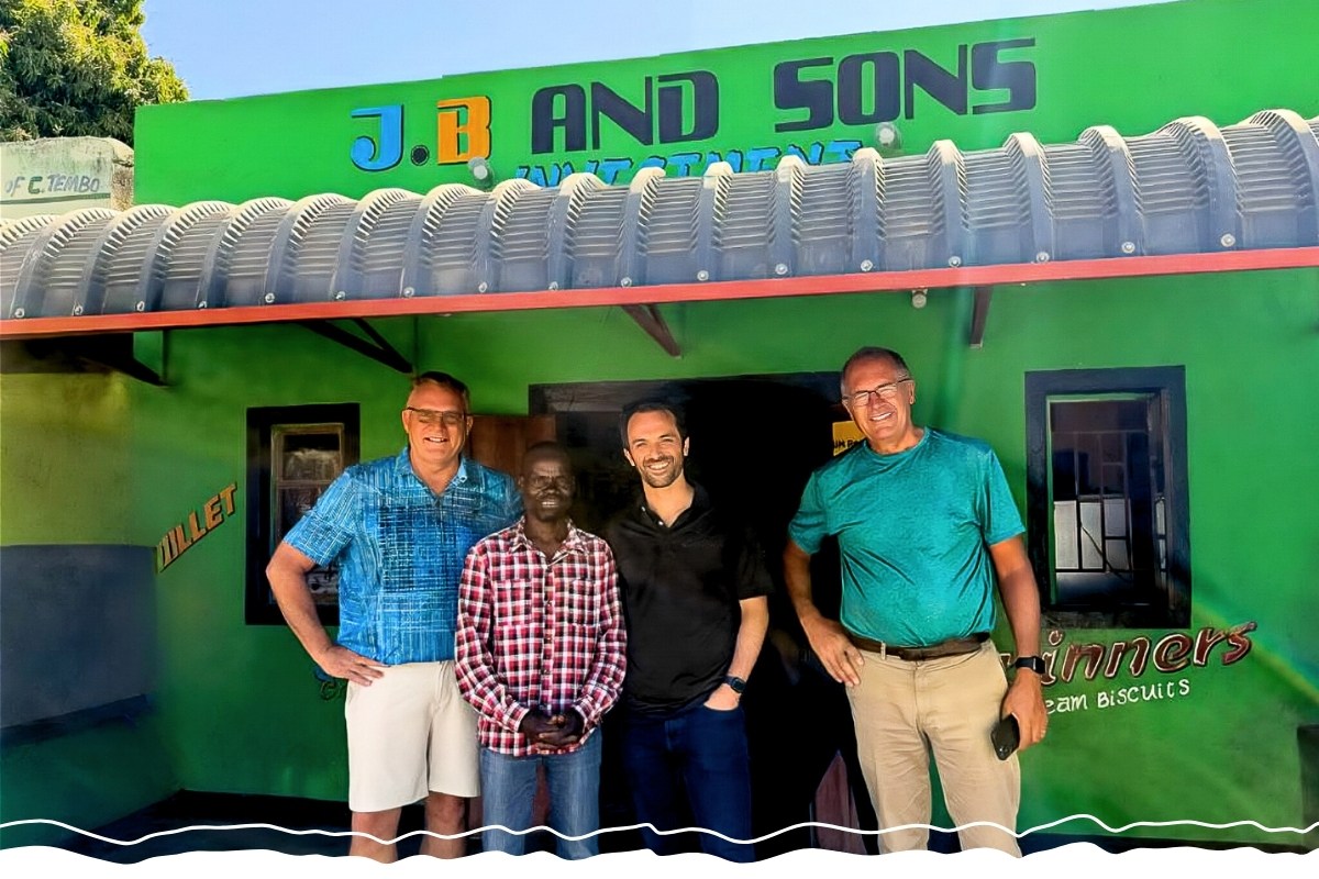 A man stands in front of his store with three other men