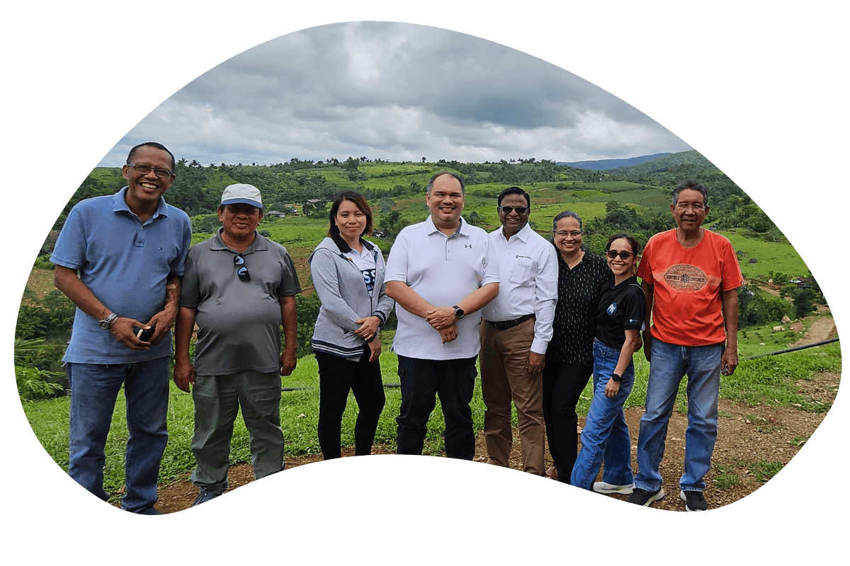 eight people stand in front of green rolling hills