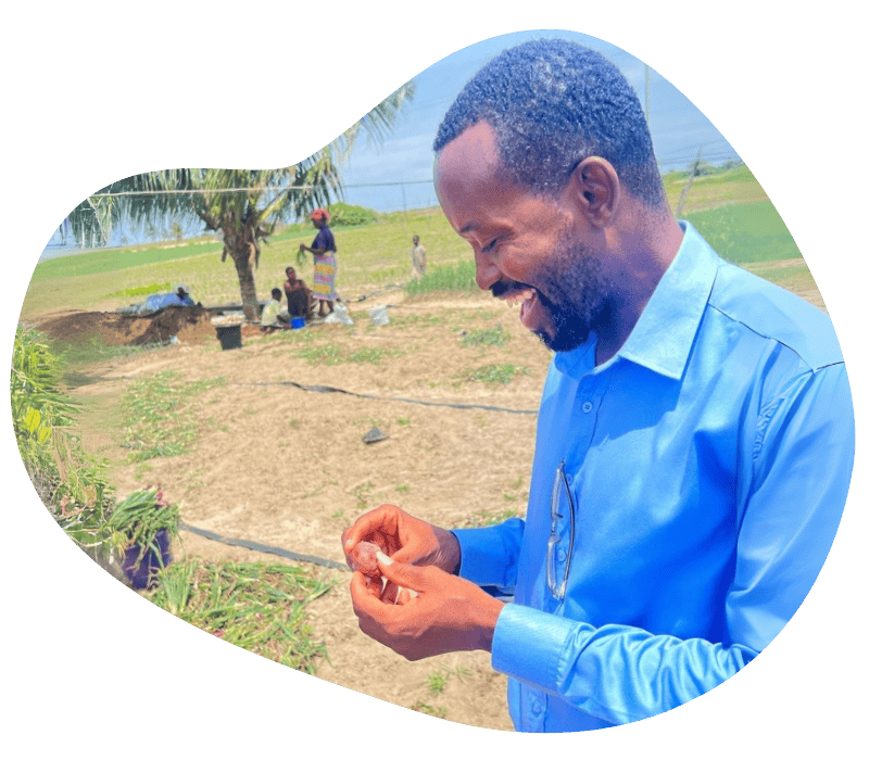 a man smiles while holding a radish